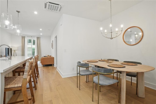 230 New St Unit 2102, Decatur, GA 30030 - dining area featuring visible vents, light wood-type flooring, baseboards, and an inviting chandelier