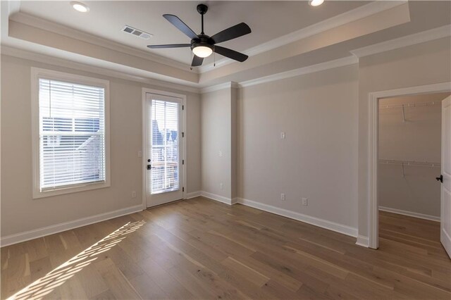 unfurnished room with crown molding, a tray ceiling, ceiling fan, and hardwood / wood-style flooring