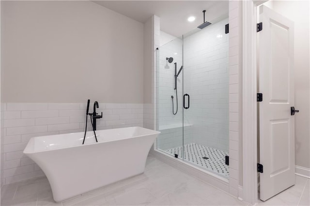 bathroom with separate shower and tub and tile walls