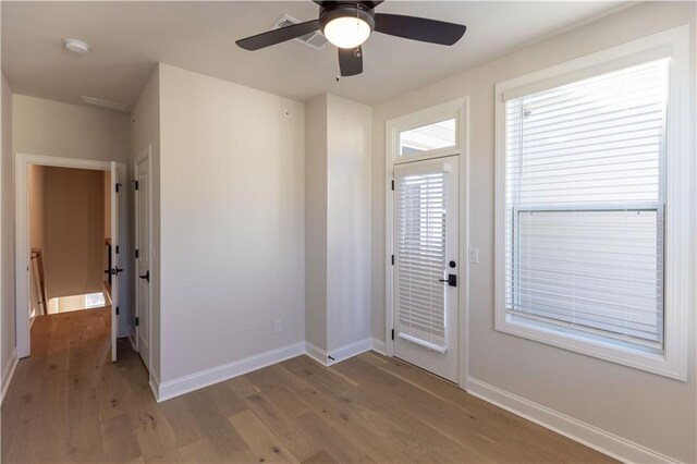 foyer entrance with ceiling fan and wood-type flooring