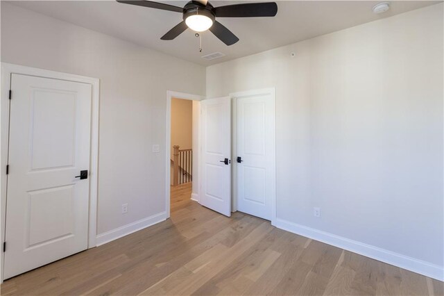 unfurnished bedroom featuring light wood-type flooring and ceiling fan