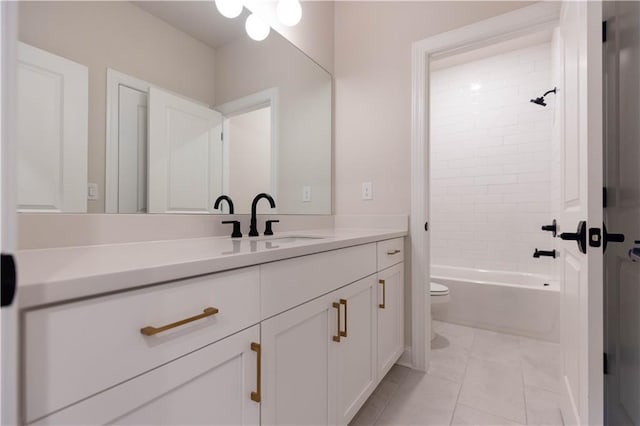 full bathroom featuring tile patterned flooring, vanity, tiled shower / bath, and toilet