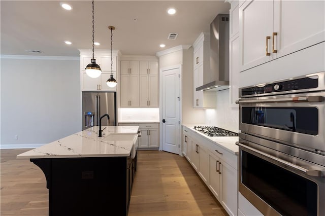 kitchen featuring sink, light hardwood / wood-style flooring, stainless steel appliances, and wall chimney exhaust hood