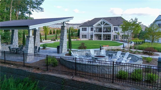 view of community with a patio, a gazebo, a lawn, and an outdoor fire pit