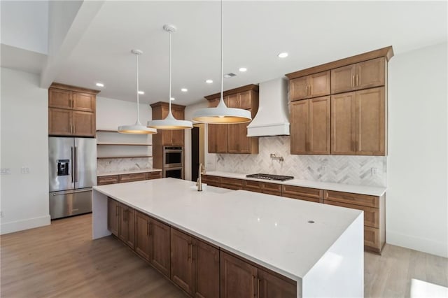 kitchen with premium range hood, appliances with stainless steel finishes, a large island, and decorative light fixtures