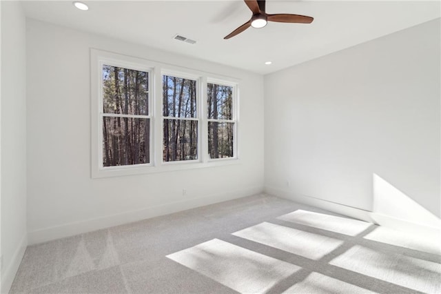 carpeted spare room with ceiling fan and a wealth of natural light