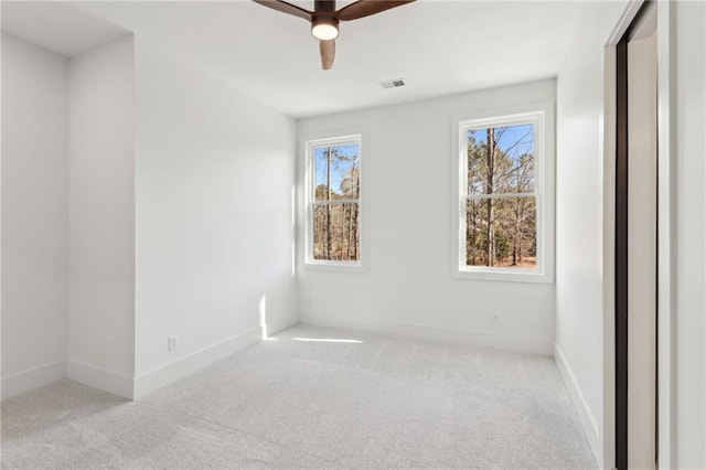 unfurnished room with ceiling fan, light colored carpet, and a healthy amount of sunlight