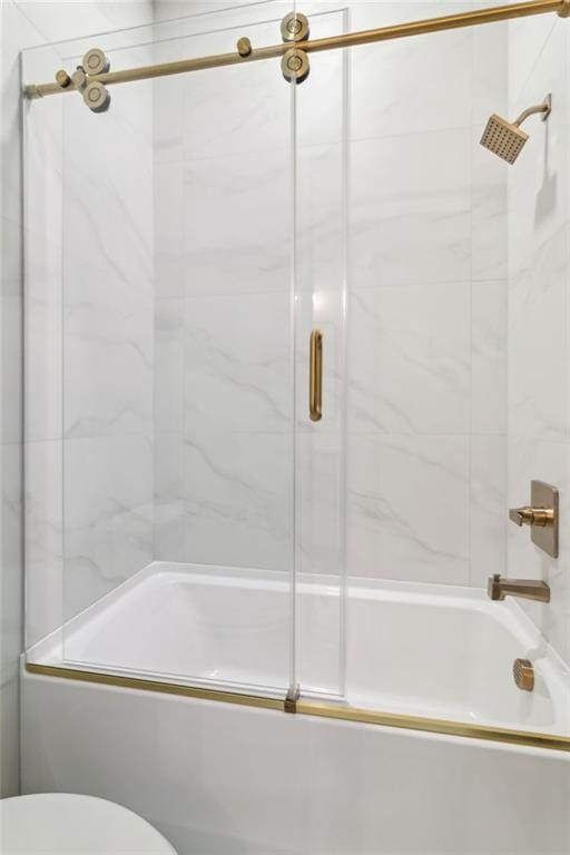 bathroom featuring shower / bath combination with glass door and toilet