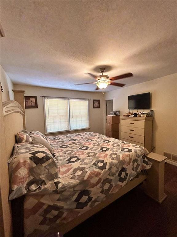 bedroom with ceiling fan and a textured ceiling