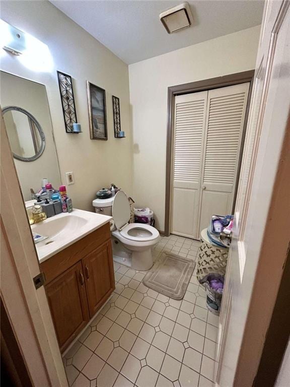 bathroom with vanity, toilet, and tile patterned flooring