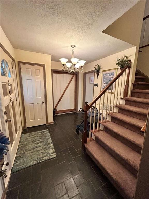 entryway with a textured ceiling and an inviting chandelier