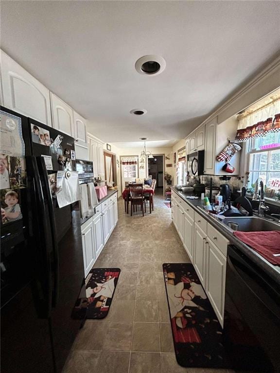 kitchen featuring black appliances, sink, and white cabinets