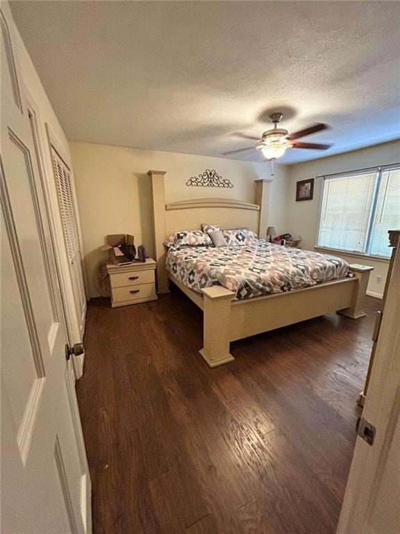 bedroom featuring dark wood-type flooring, a textured ceiling, ceiling fan, and a closet