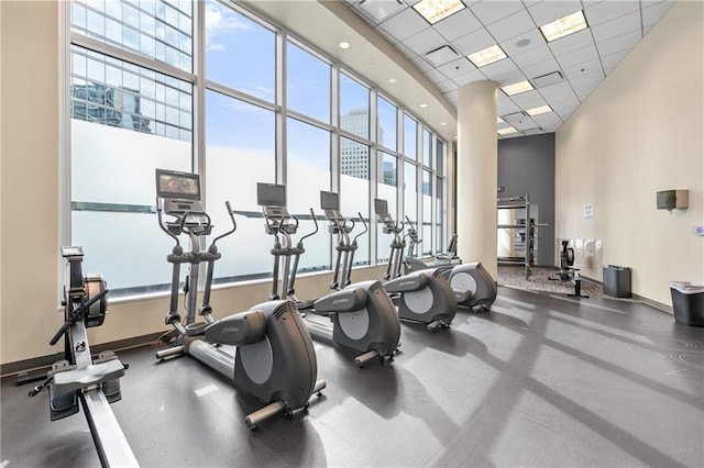 gym with a paneled ceiling and a towering ceiling