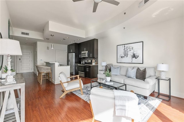 living room featuring wood-type flooring and ceiling fan