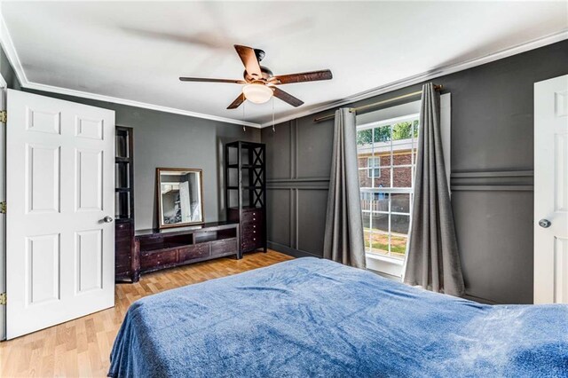 bedroom featuring light hardwood / wood-style floors, ceiling fan, and crown molding