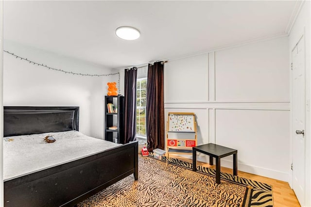 bedroom with light hardwood / wood-style flooring and ornamental molding