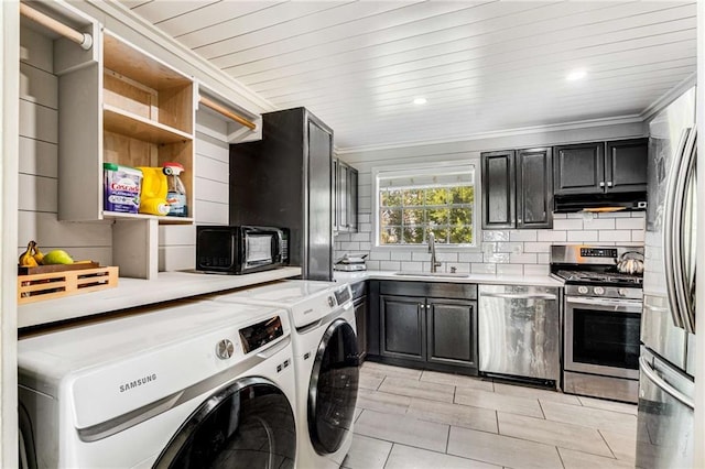 laundry room with ornamental molding, separate washer and dryer, and sink