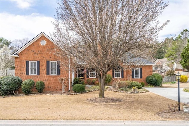 view of front of home featuring fence and brick siding