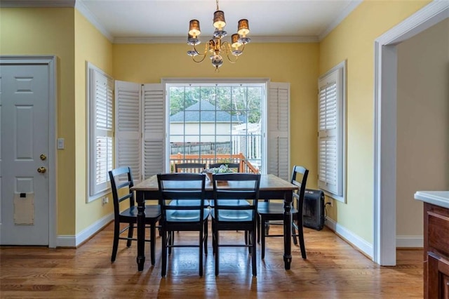 dining area with wood finished floors, baseboards, and ornamental molding