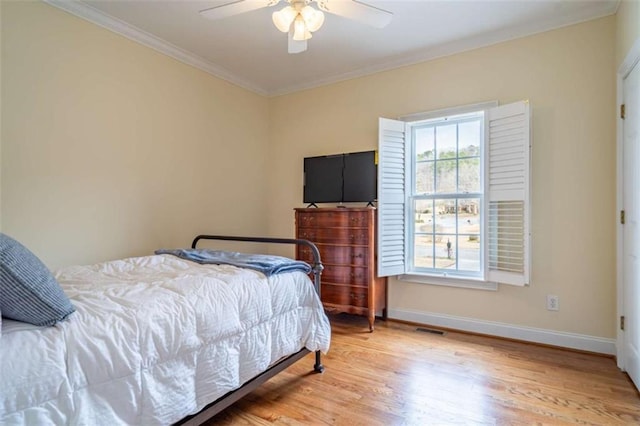 bedroom featuring visible vents, crown molding, ceiling fan, baseboards, and light wood-type flooring