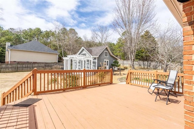 wooden deck featuring an outdoor structure and a fenced backyard