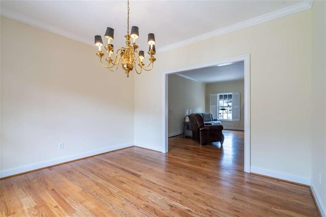 unfurnished room with crown molding, a notable chandelier, baseboards, and light wood-type flooring