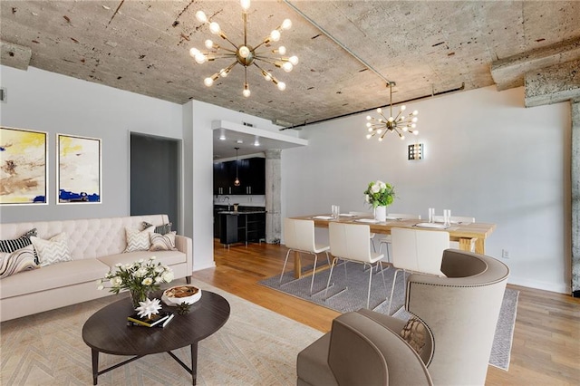 living room with light wood-type flooring and a notable chandelier