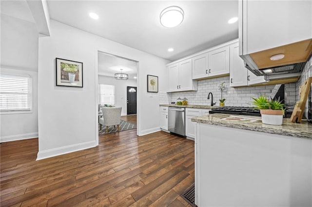 kitchen with light stone countertops, white cabinets, dark wood-type flooring, backsplash, and stainless steel dishwasher