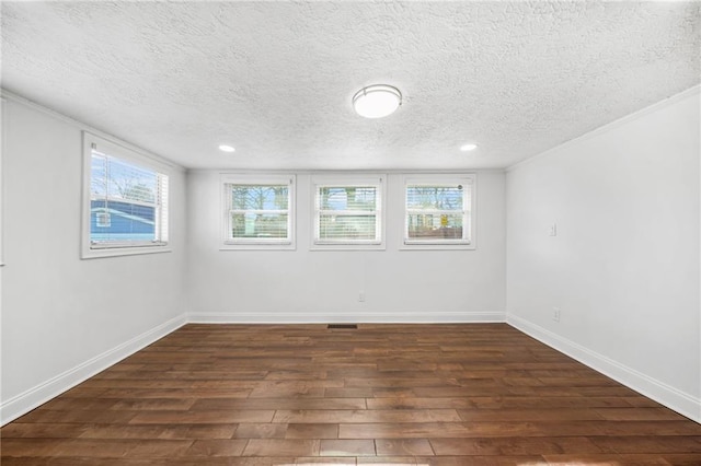 empty room with dark wood-type flooring and a textured ceiling