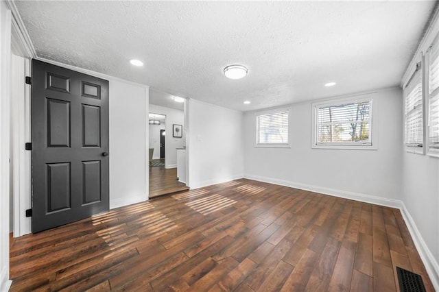 unfurnished room featuring a textured ceiling and dark hardwood / wood-style flooring