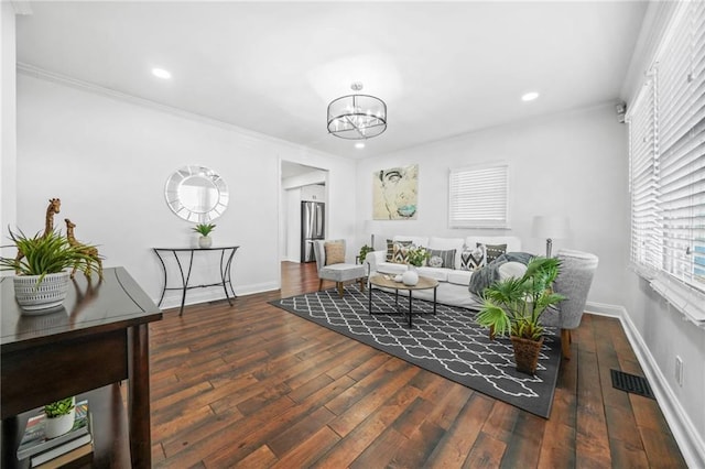 living room featuring crown molding, dark wood-type flooring, and a notable chandelier