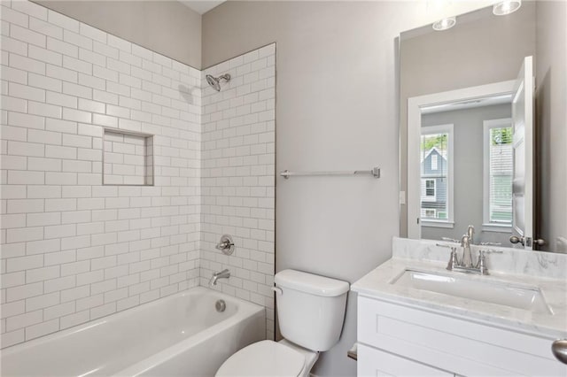 full bathroom with toilet, tiled shower / bath, and vanity