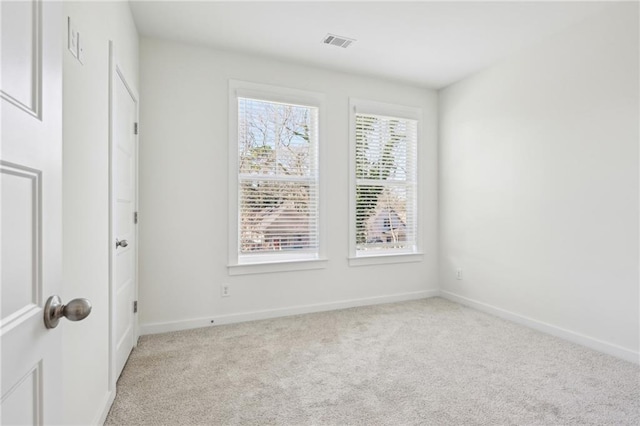 empty room featuring light carpet, baseboards, and visible vents