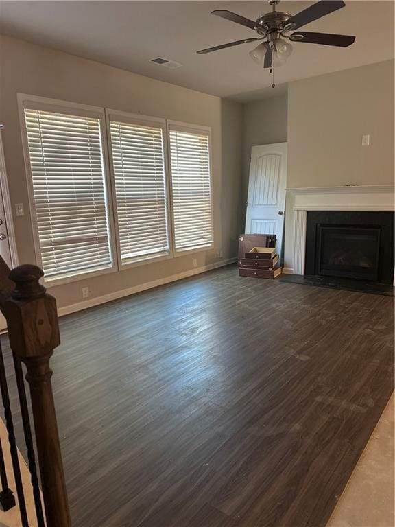 unfurnished living room with ceiling fan and dark hardwood / wood-style flooring