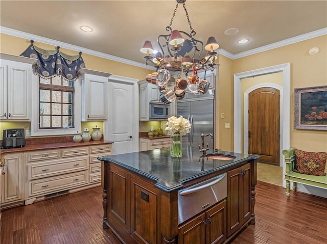 kitchen featuring a sink, built in appliances, a warming drawer, and crown molding