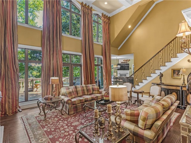 living room featuring stairway, plenty of natural light, a high ceiling, and a fireplace