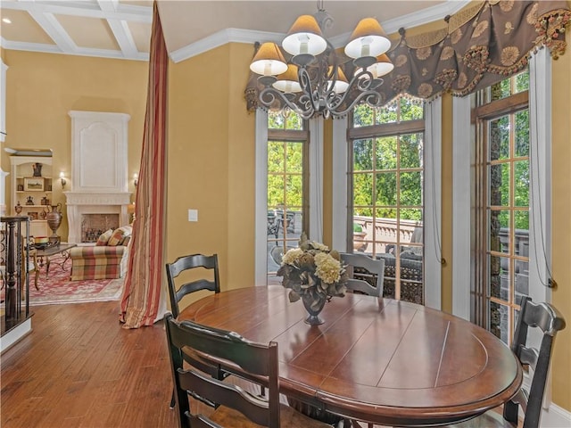 dining space featuring plenty of natural light, coffered ceiling, wood finished floors, a high end fireplace, and a chandelier