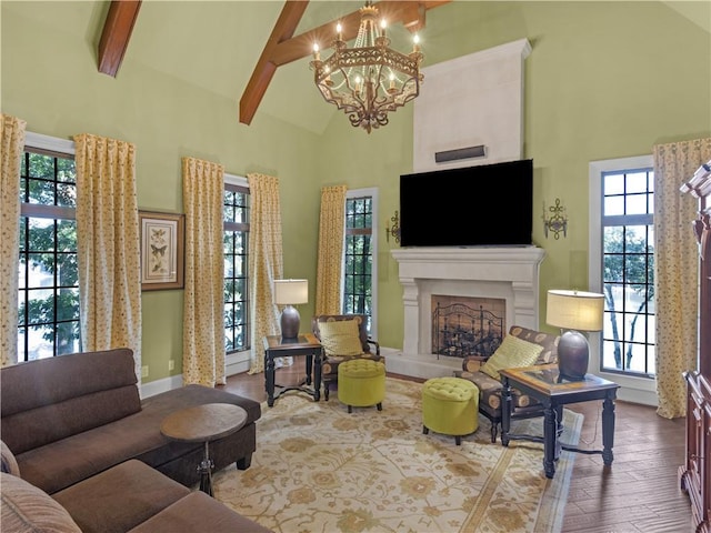 living room with wood finished floors, high vaulted ceiling, beam ceiling, a fireplace, and a chandelier