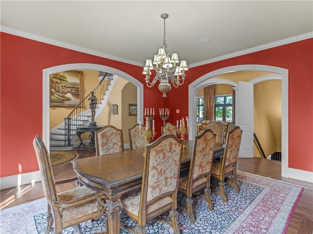 dining area with baseboards, arched walkways, a notable chandelier, and ornamental molding