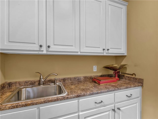 interior space featuring white cabinetry and a sink