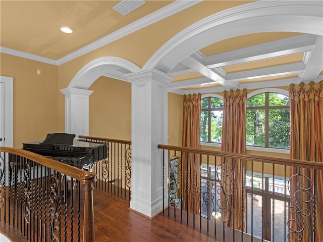 corridor with visible vents, ornamental molding, beam ceiling, wood finished floors, and coffered ceiling