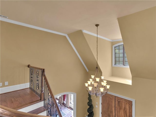 room details featuring visible vents, a chandelier, ornamental molding, wood finished floors, and arched walkways