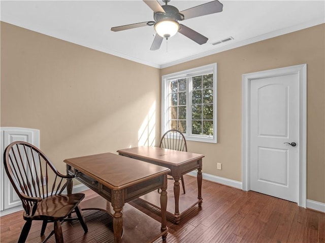 office area featuring visible vents, baseboards, wood finished floors, and crown molding