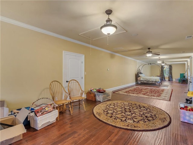 interior space with attic access, wood finished floors, visible vents, and ornamental molding