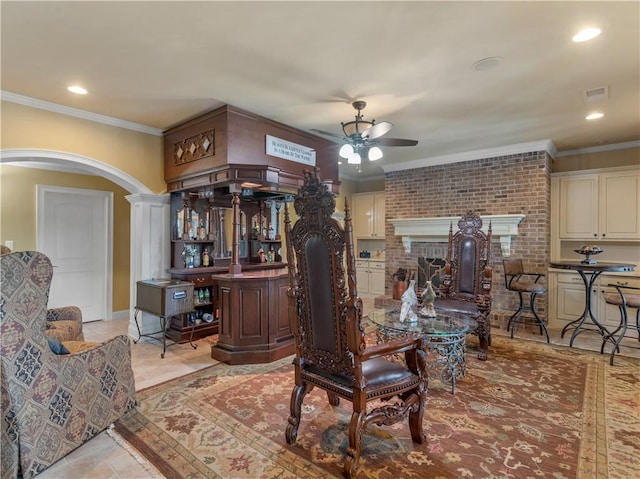 interior space featuring ceiling fan, arched walkways, visible vents, and ornamental molding