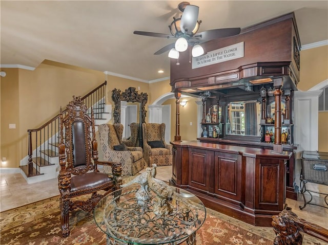 bar featuring arched walkways, stairway, ceiling fan, and ornamental molding