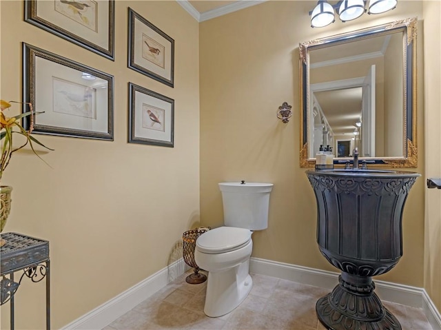 half bath featuring a sink, baseboards, toilet, and ornamental molding