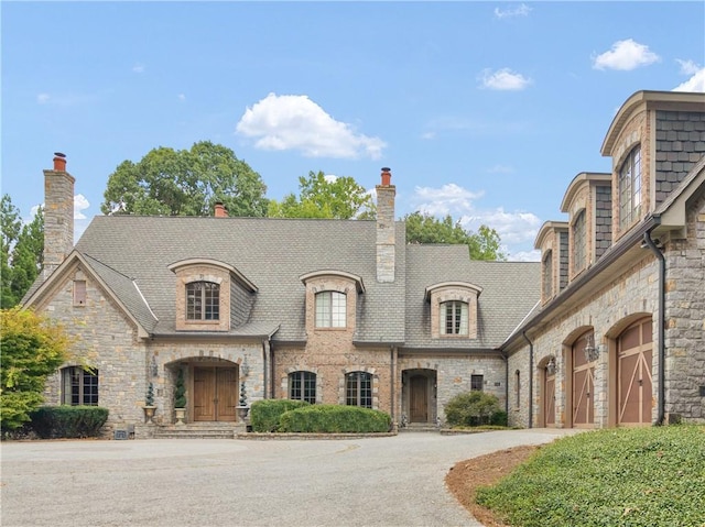 french country home featuring driveway and a garage