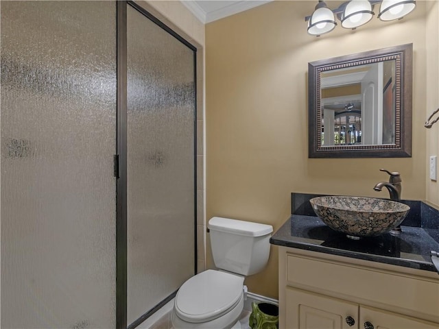 bathroom with vanity, crown molding, toilet, and a stall shower